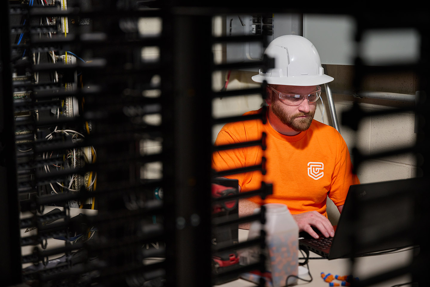 TC Controls technician programming BMS controls logic on a laptop in the building's server room