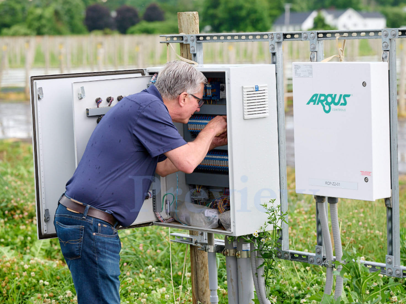 TC Controls technician servicing an outdoor Argus field control panel at Nourse Farms