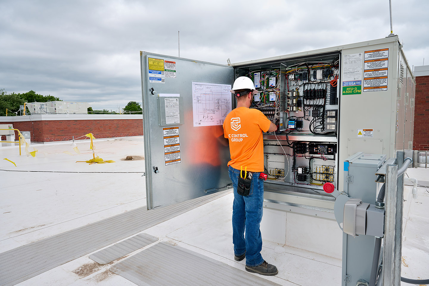 TC Controls technician installing controls inside an open rooftop RTU control panel at the Springfield office building