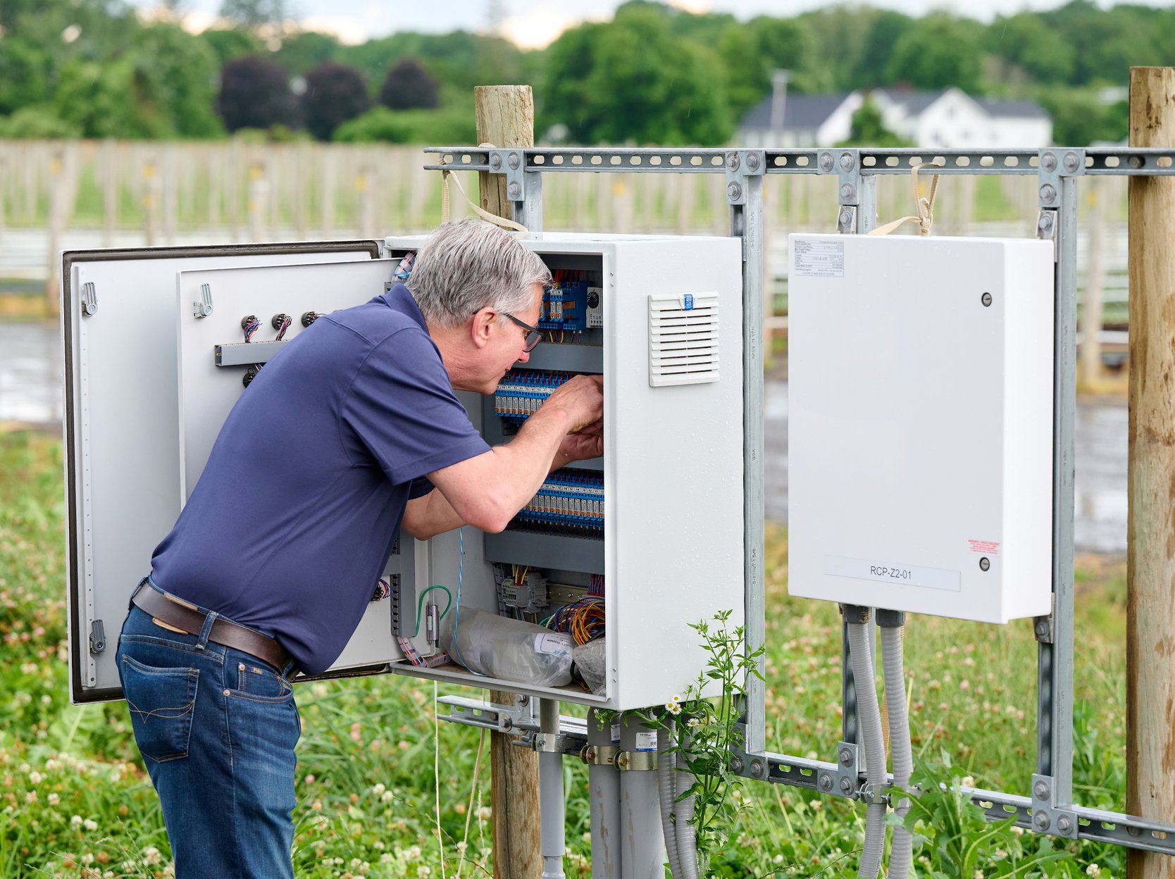 TC Controls technician servicing an outdoor Argus field control panel at Nourse Farms